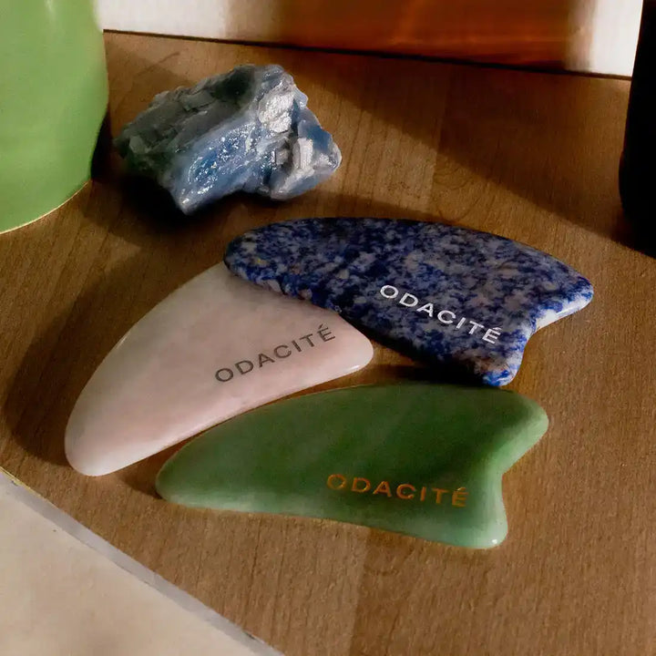 Three polished stone or crystal pieces labeled ’ODACITE’ in different colors and patterns.